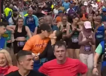 The adorable moment a man and a woman high five and kiss at the finish line of the Cardiff Half Marathon
