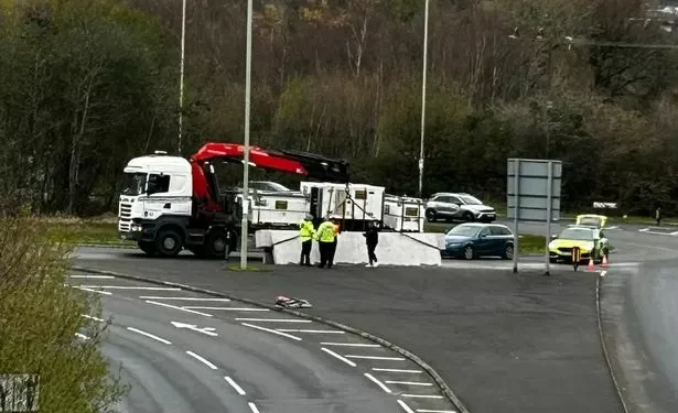 Heavy goods spilled off lorry onto busy roundabout