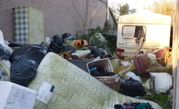 ‘Eyesore’ piles of rubbish and old caravan finally removed from Swansea garden